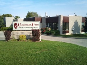 Outside entrance and driveway of Woodstock Retirement home with Caressant Care sign 