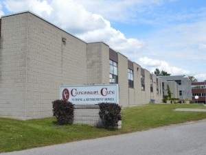 Outside entrance and driveway of Woodstock Retirement home with Caressant Care sign 