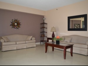 Inside seating area with two large taupe couches with table and wall art 