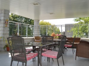 Outdoor seating area with roof over top, and two tables and chairs
